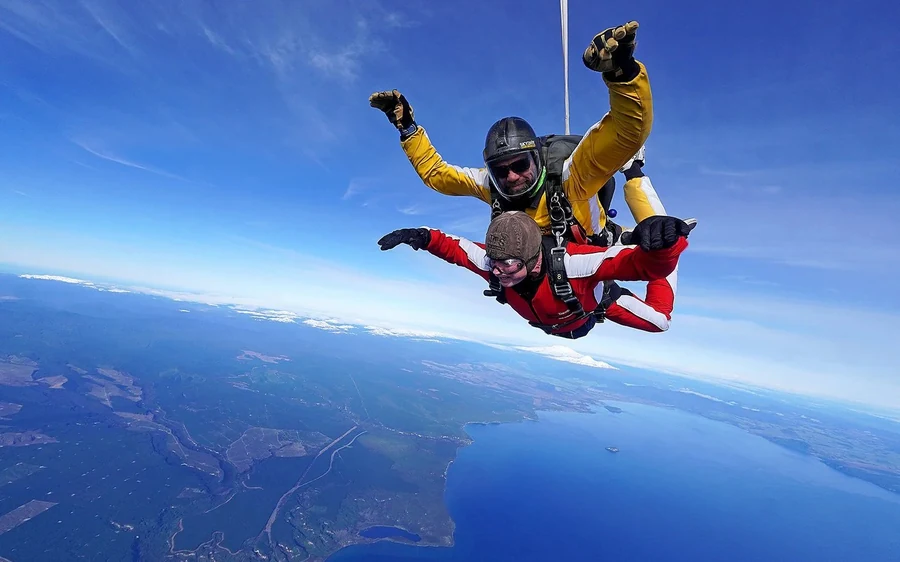 A tandem skydiver in freefall above Lake Taupo