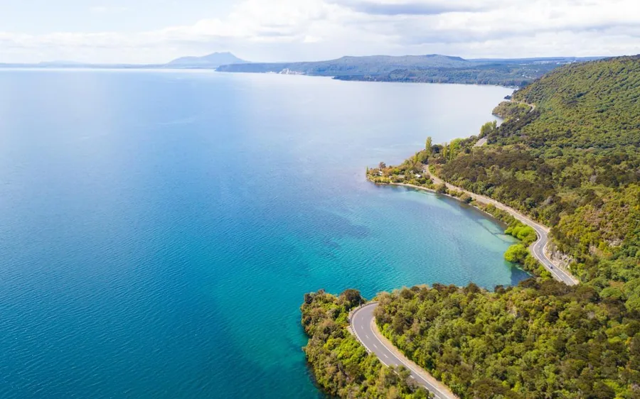The shoreline and green headlands of Lake Taupo seen from a helicopter